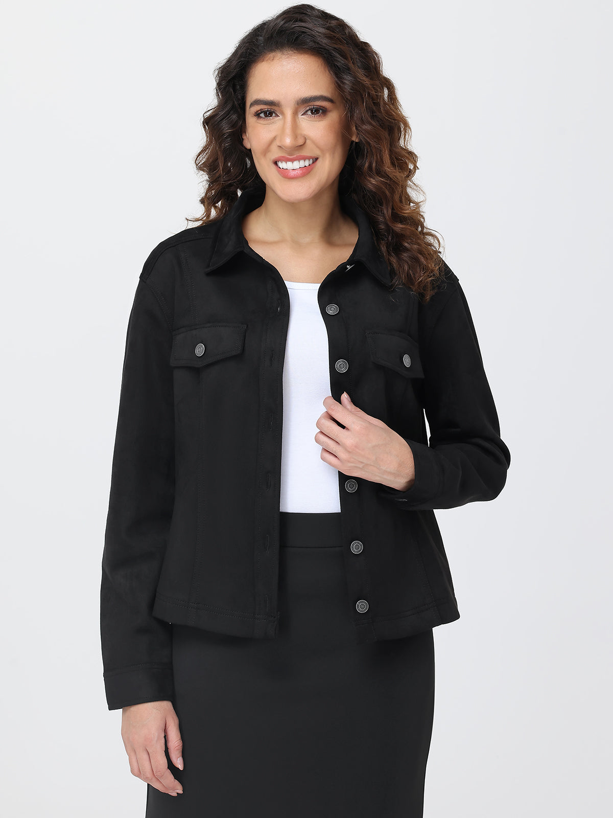 Woman wearing a black jacket over a white shirt on a plain background