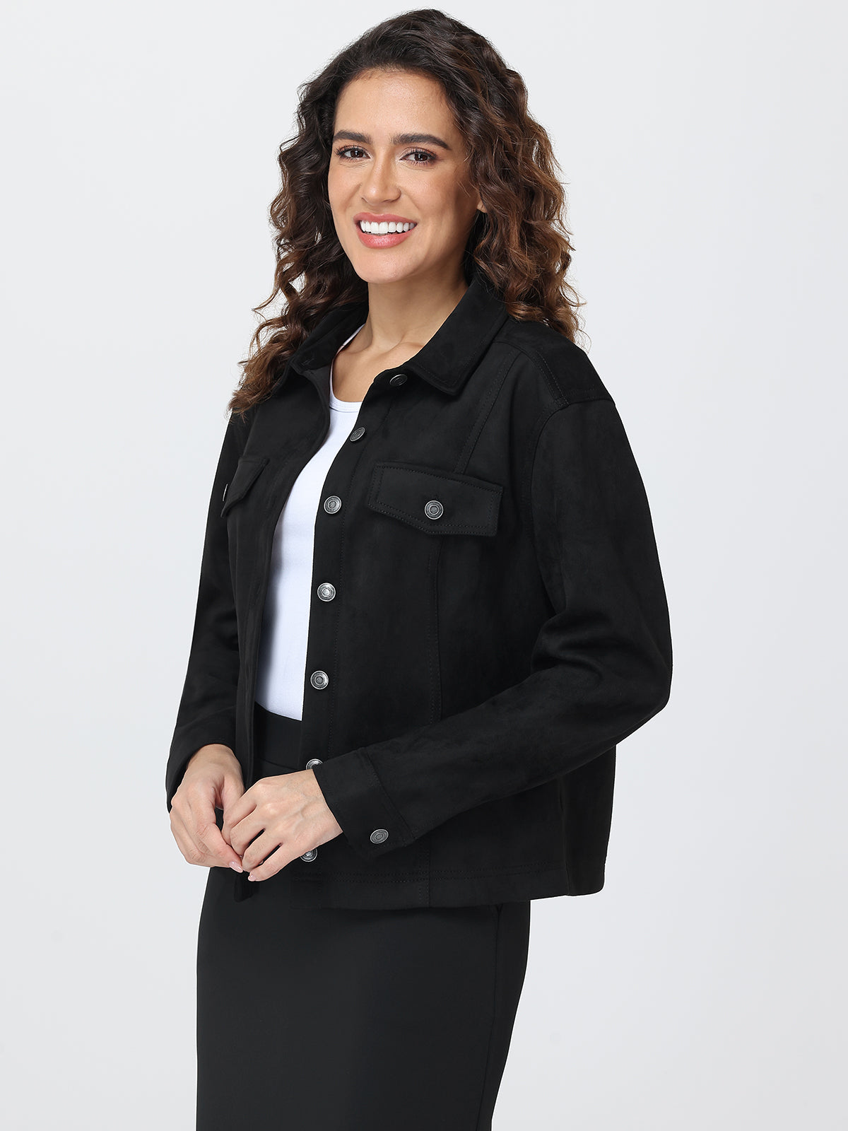 Woman wearing a black jacket over a white shirt on a light gray background