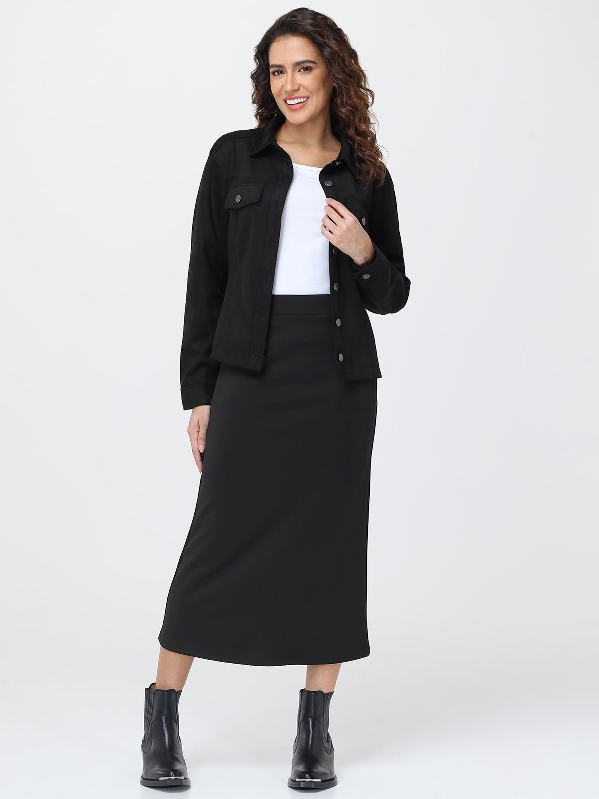 Woman wearing a black jacket, white shirt, and black skirt on a white background