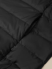 Close-up of a black puffer jacket showing horizontal quilting and a black zipper detail.