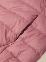 Close-up of a dusty pink puffer jacket showing the quilted stitching and a dark zipper running diagonally through the center.