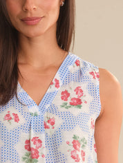 Woman wearing a sleeveless top with floral and checkered pattern