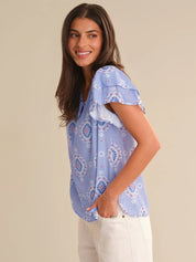 Woman wearing a blue floral blouse against a beige background