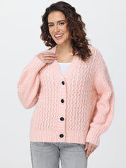 Woman wearing a pink knitted cardigan on a white background