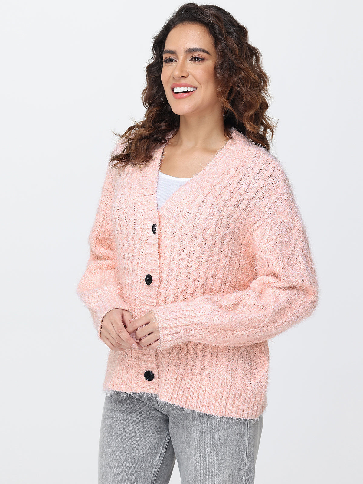 Woman wearing a pink knitted cardigan on a white background