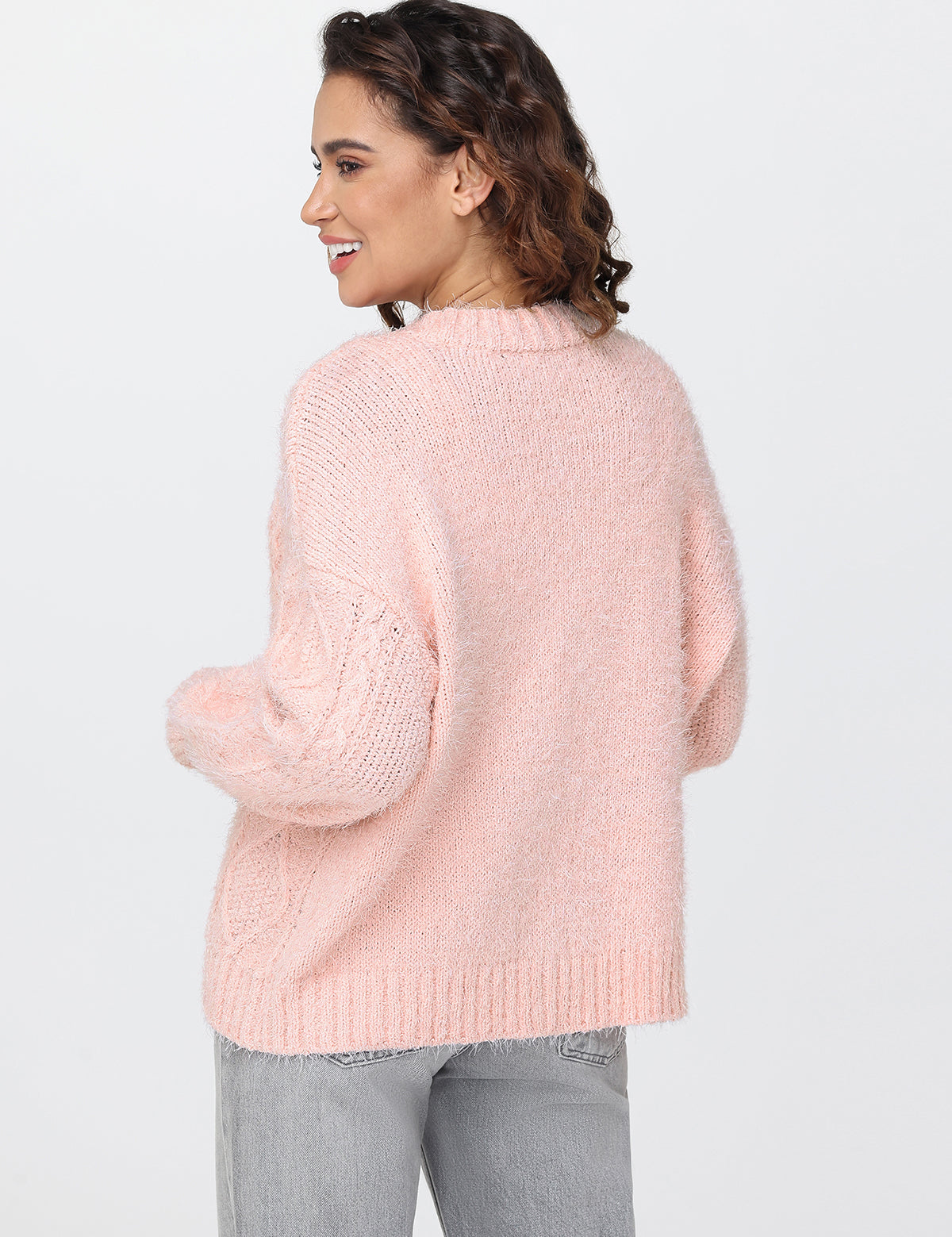 Woman wearing a pink sweater on a white background
