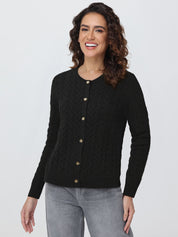 Woman wearing a black cardigan with gold buttons on a white background