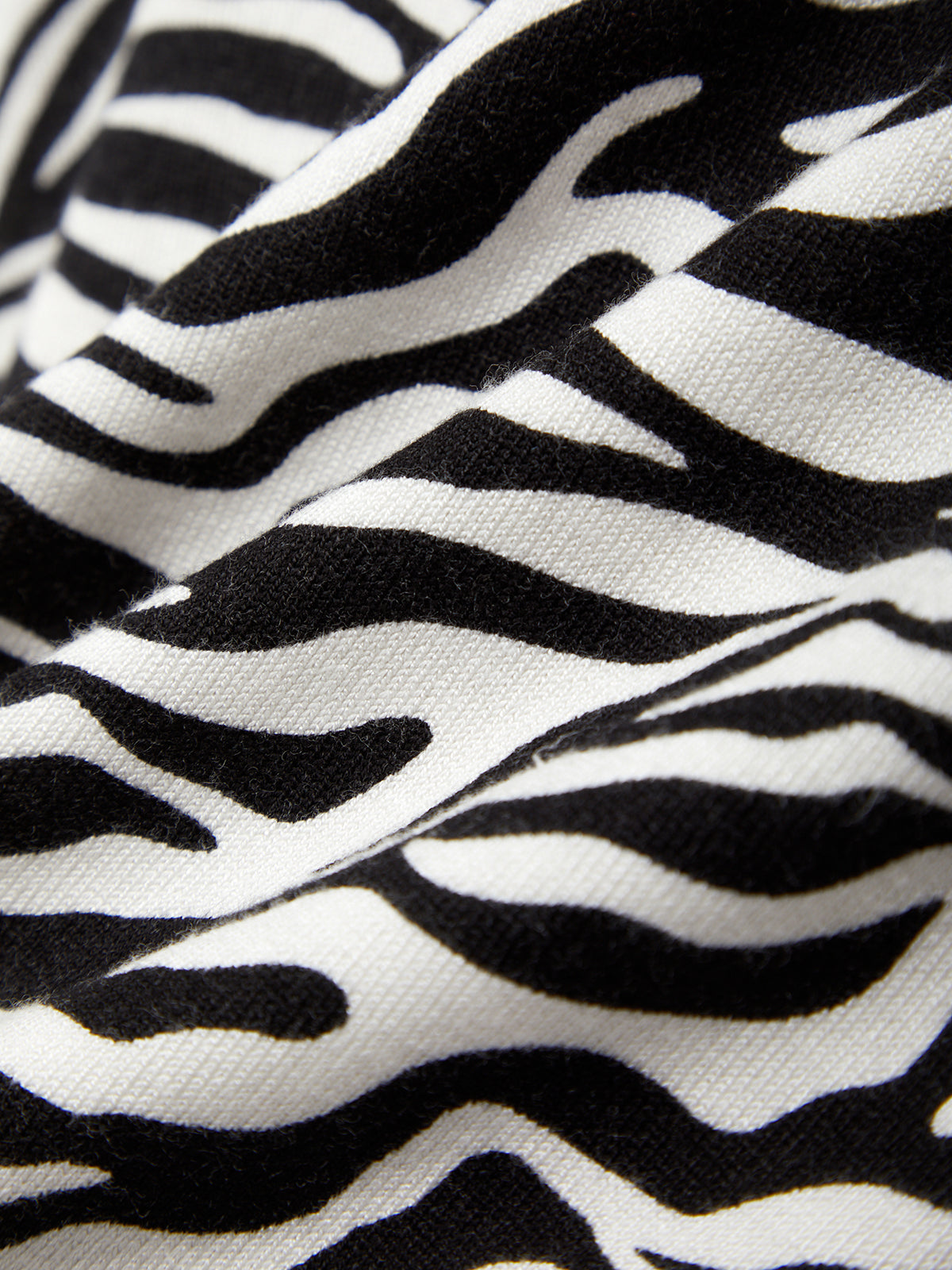 Close-up of zebra pattern fabric with black and white stripes.