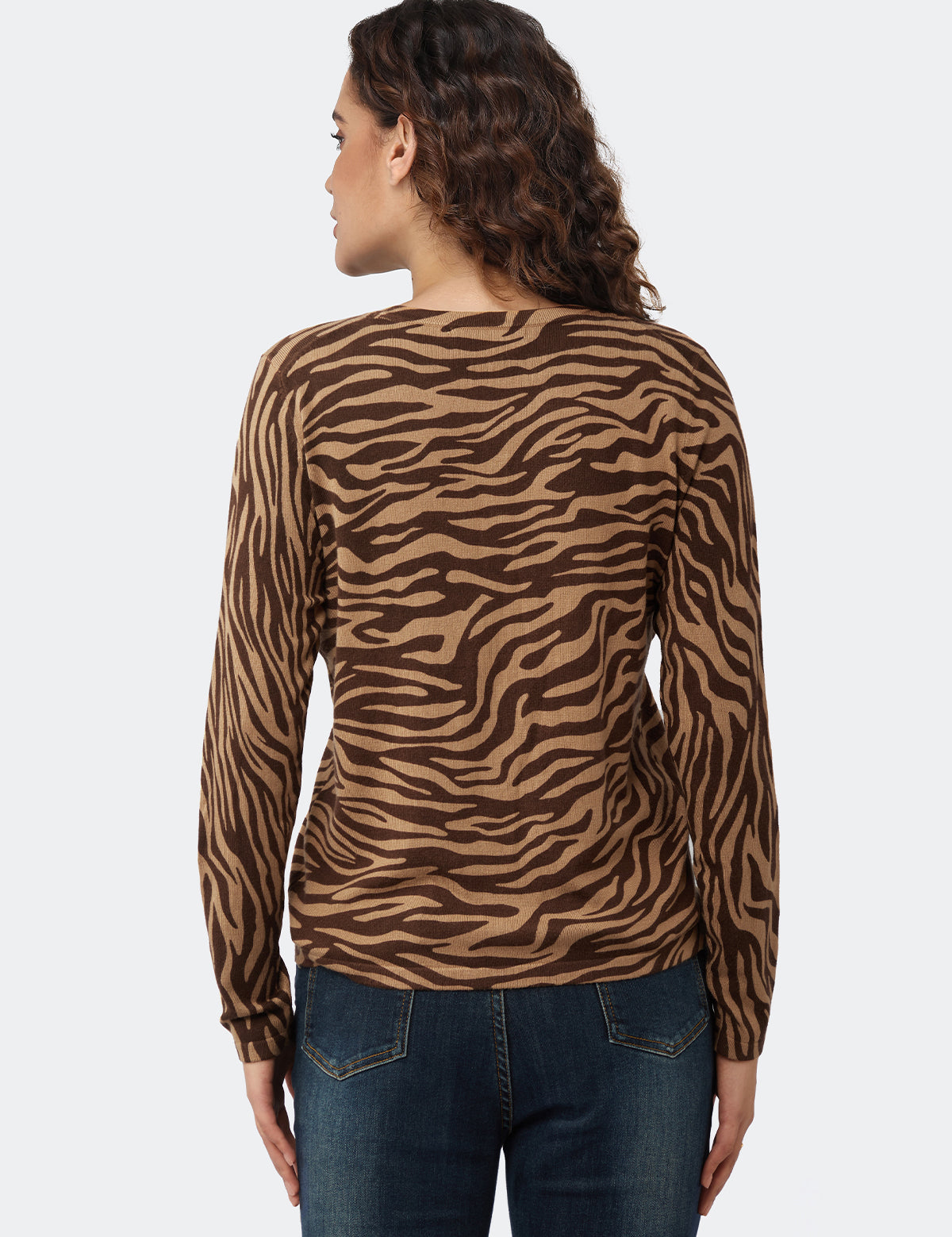 Woman wearing a brown zebra print long-sleeve top on a white background