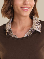Close-up of a person wearing a brown sweater with a patterned collar.