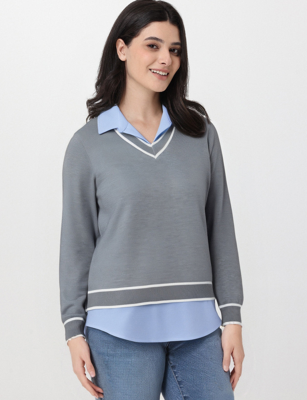 Woman wearing a gray sweater over a light blue shirt on a white background