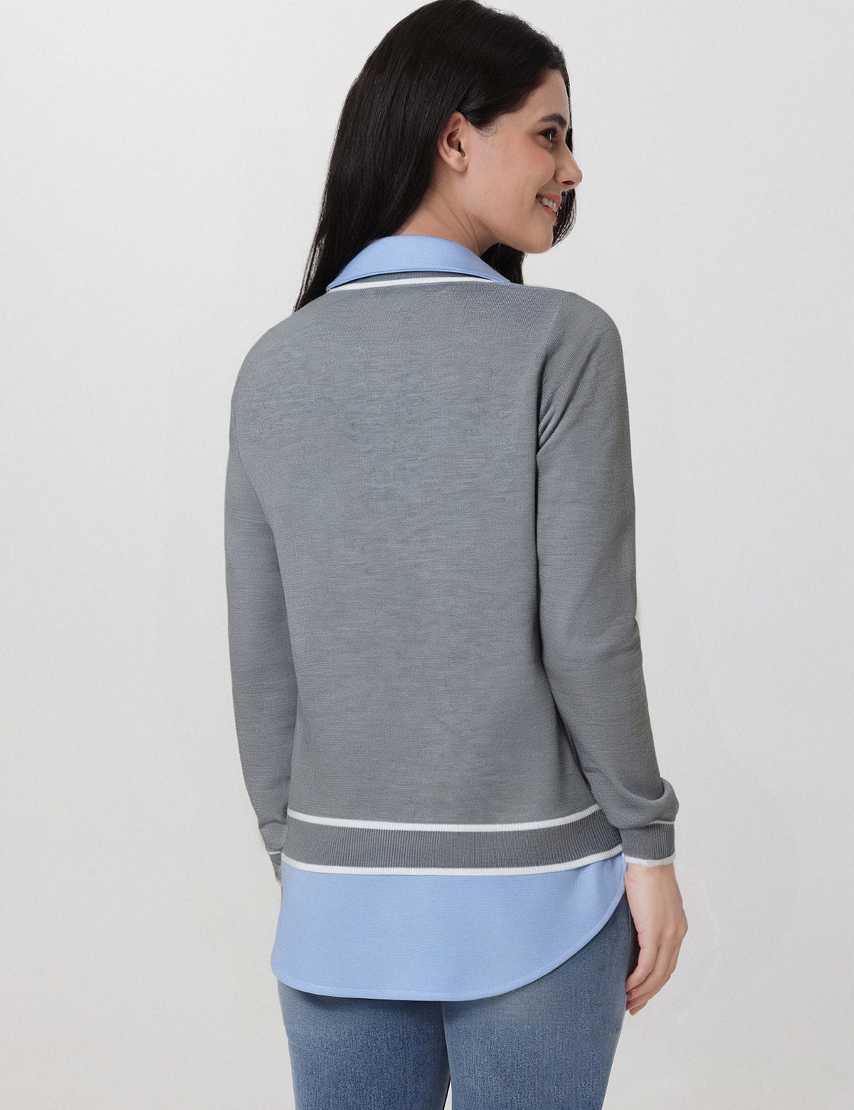 Woman wearing a gray and blue outfit with a plain background