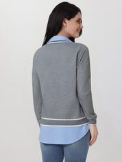 Woman wearing a gray and blue outfit with a plain background