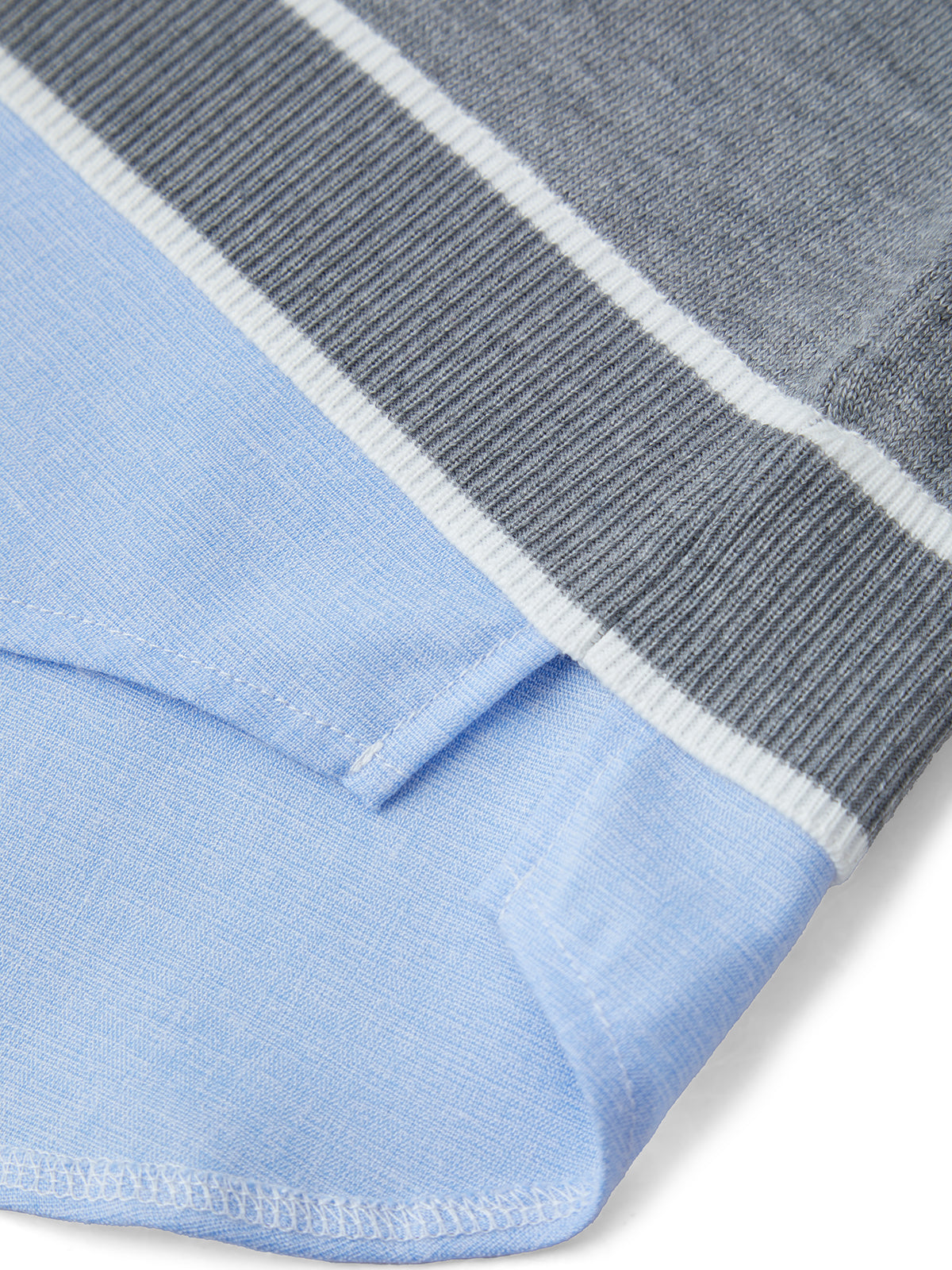 Close-up of a blue fabric with a gray and white striped border.