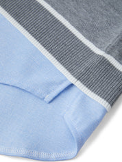 Close-up of a blue fabric with a gray and white striped border.