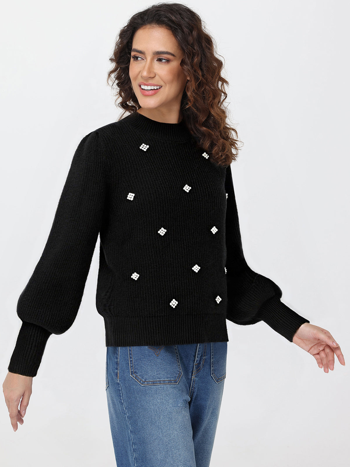 Woman wearing a black sweater with white diamond patterns on a white background