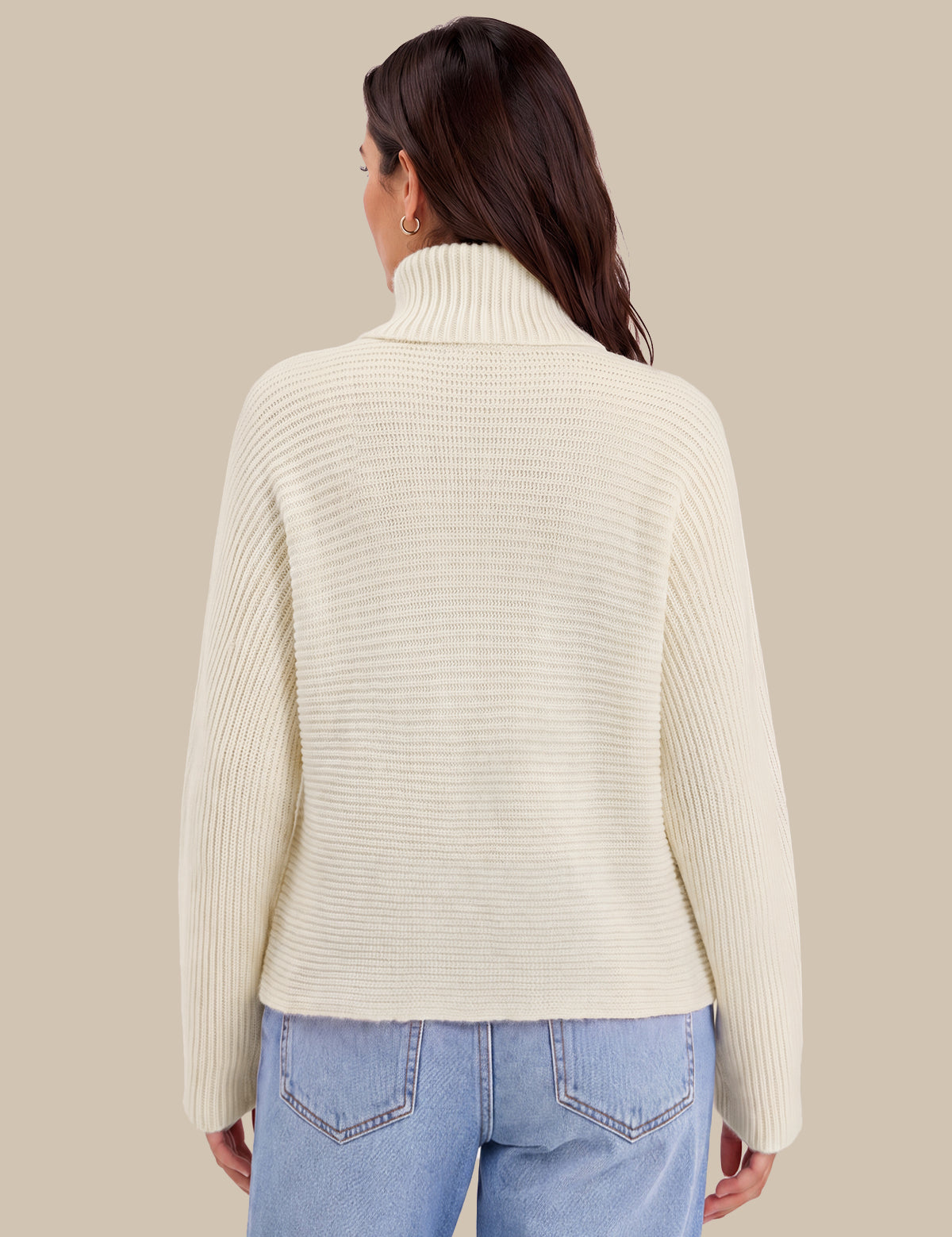 A woman shown from the back wearing a cream ribbed turtleneck sweater and light blue jeans against a solid beige background.