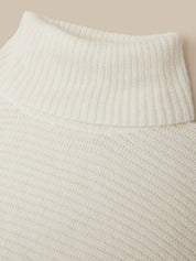 Close-up of a cream-colored ribbed knit sweater showing the high ribbed collar and textured fabric.