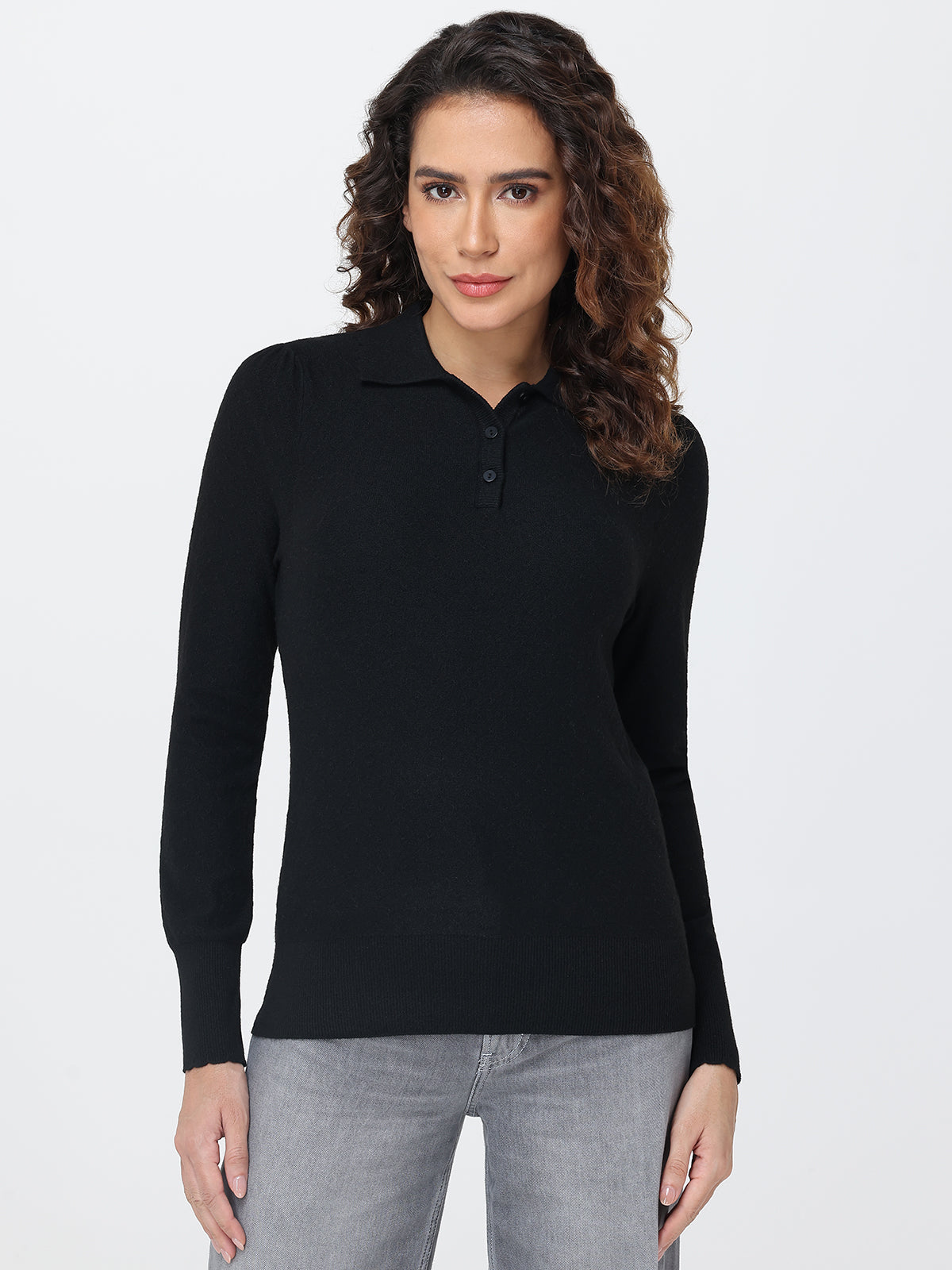 Woman wearing a black long-sleeve polo shirt against a white background