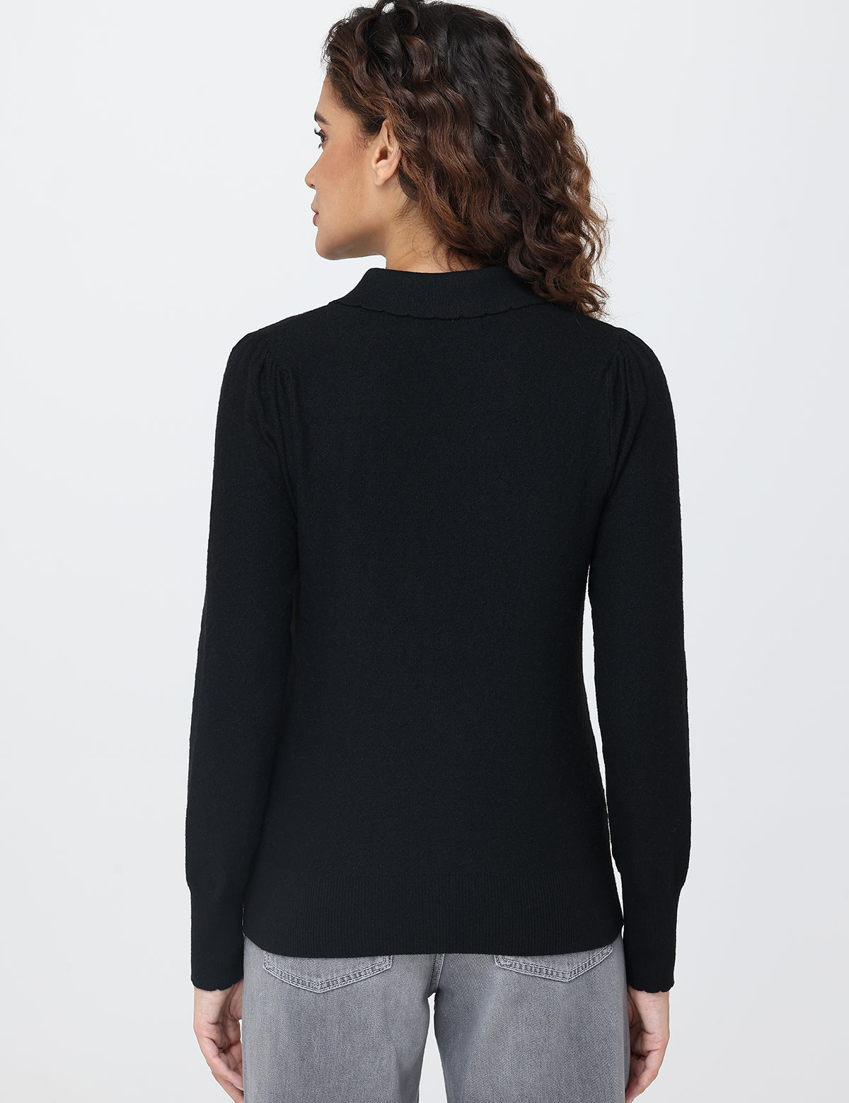 Person wearing a black long-sleeve top on a white background