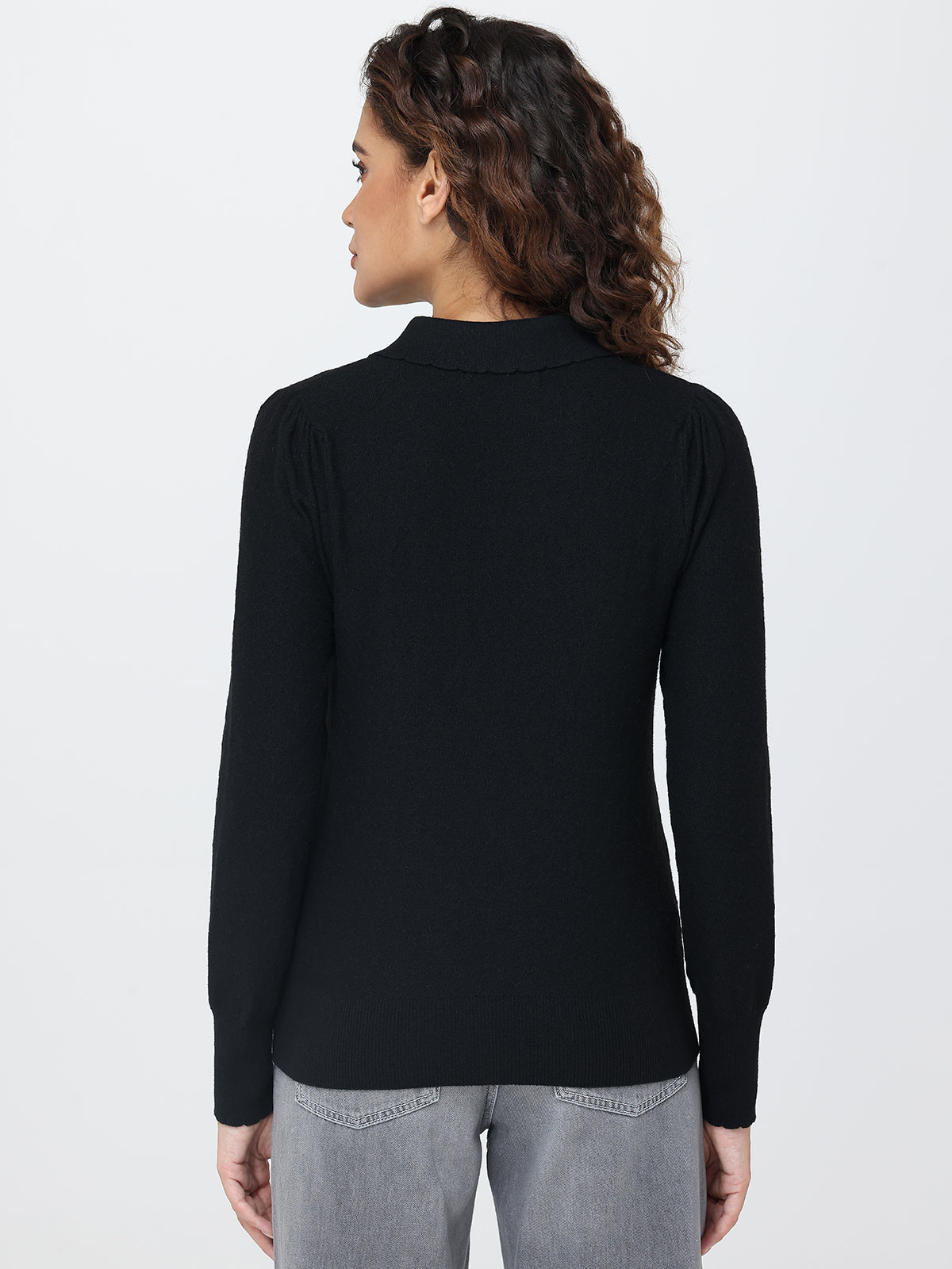 Person wearing a black long-sleeve top on a white background