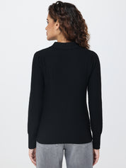Person wearing a black long-sleeve top on a white background