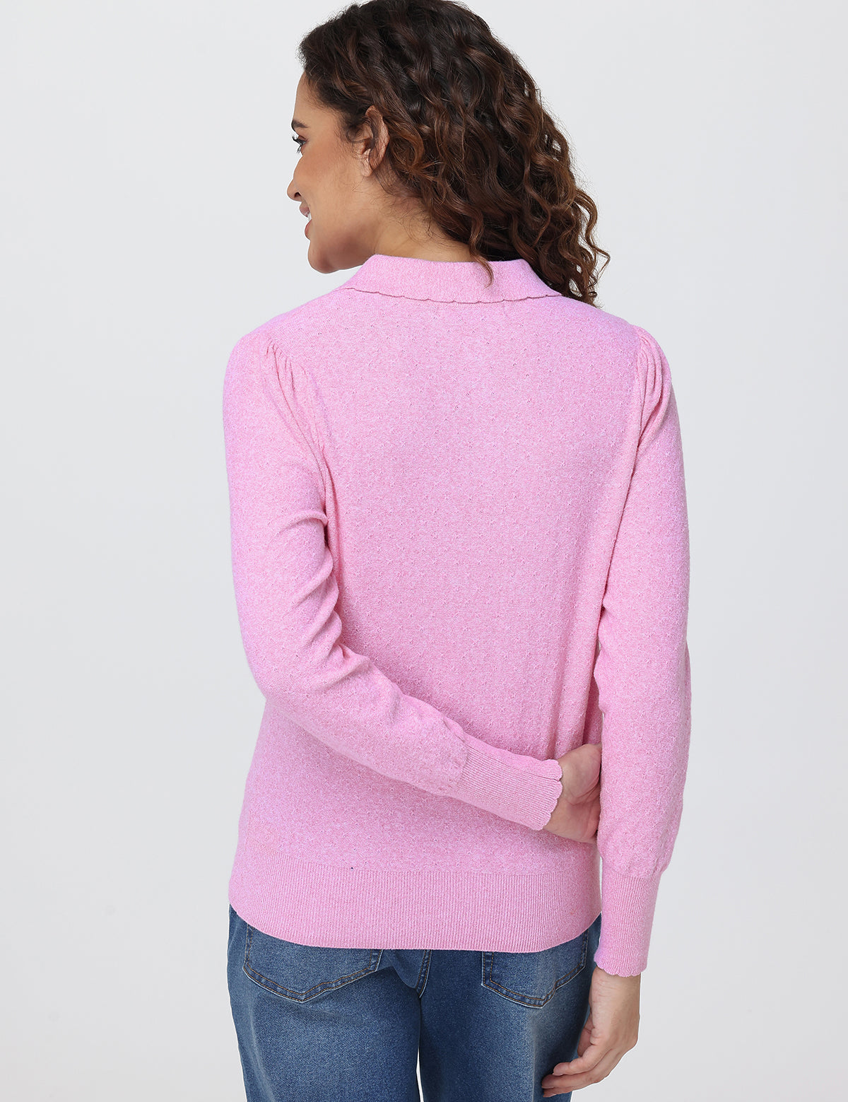 Woman wearing a pink sweater on a white background
