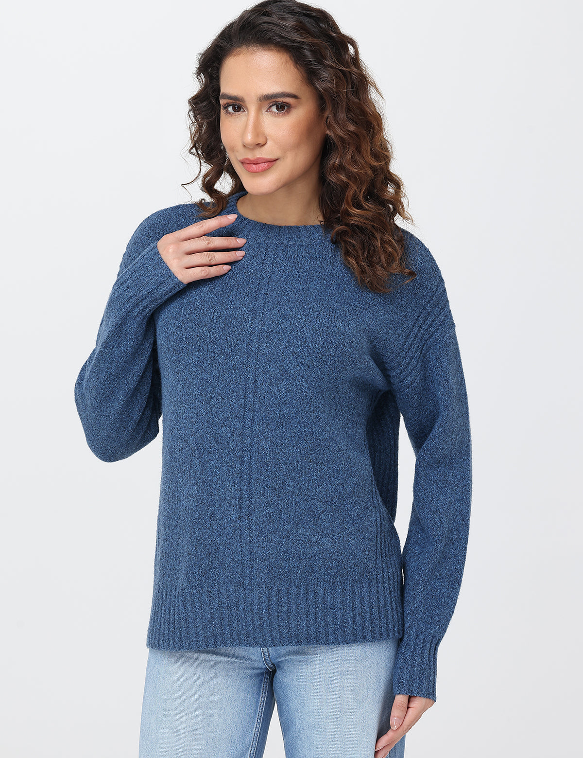 Woman wearing a blue sweater against a white background
