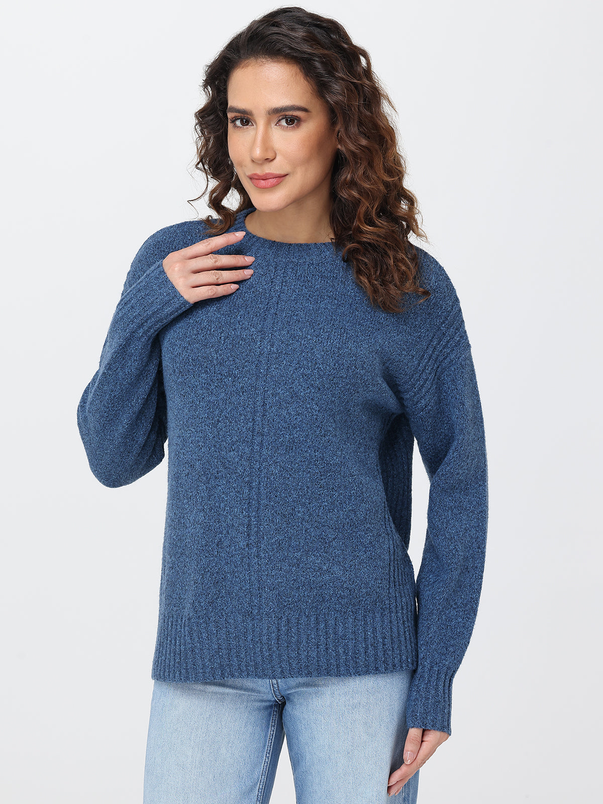 Woman wearing a blue sweater against a white background