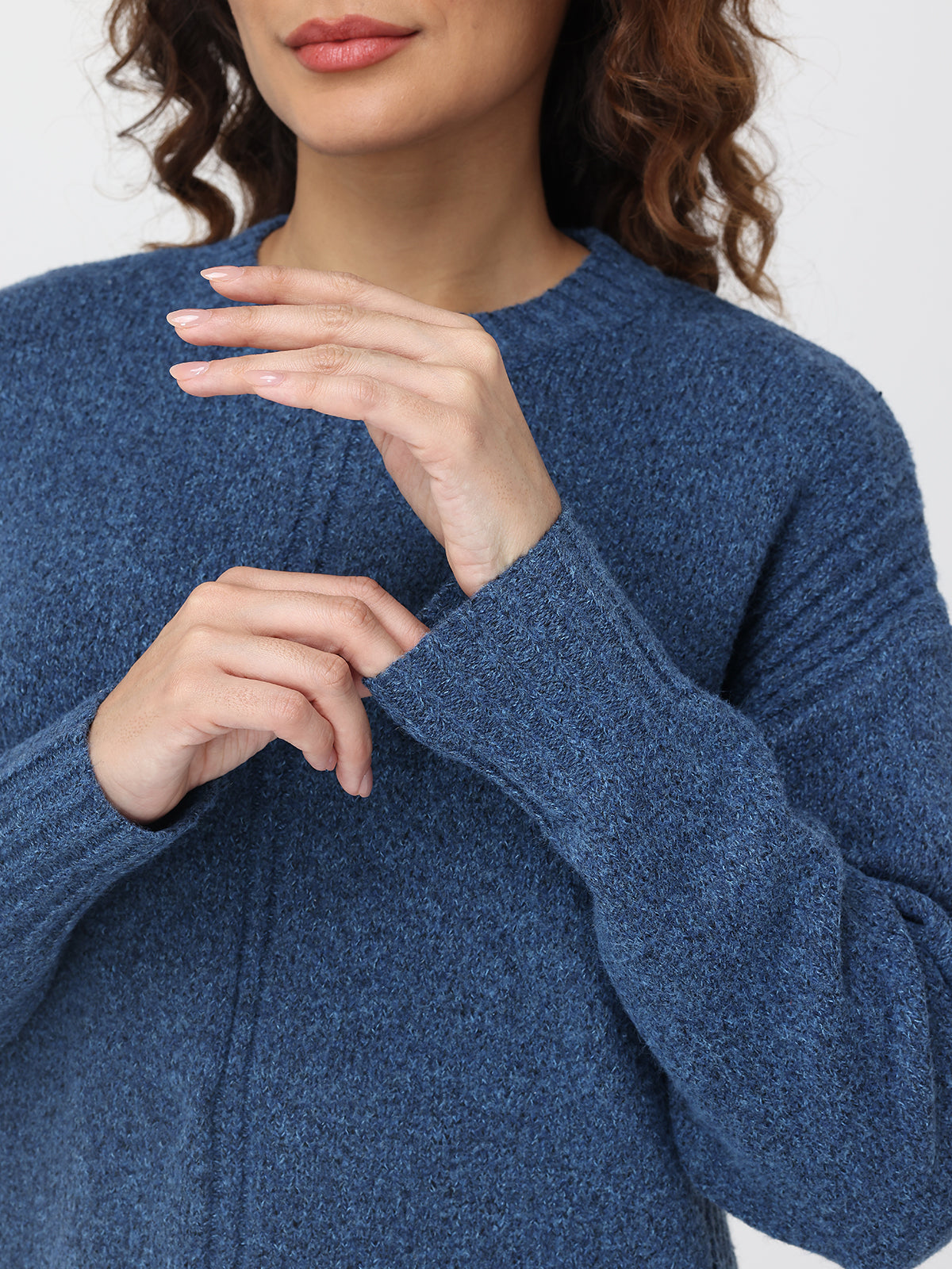Close-up of a person wearing a blue sweater with a blurred background