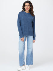 Woman wearing a blue sweater and light blue jeans on a white background