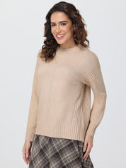 Woman wearing a beige sweater and plaid skirt on a white background