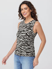 Woman wearing a zebra print sleeveless top and blue jeans on a white background