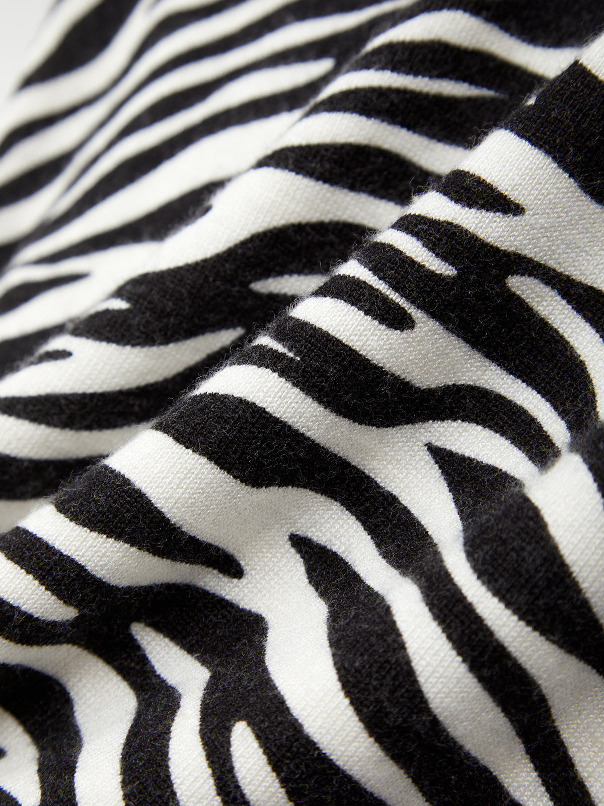 Close-up of zebra print fabric with black and white stripes.