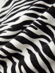 Close-up of zebra print fabric with black and white stripes.