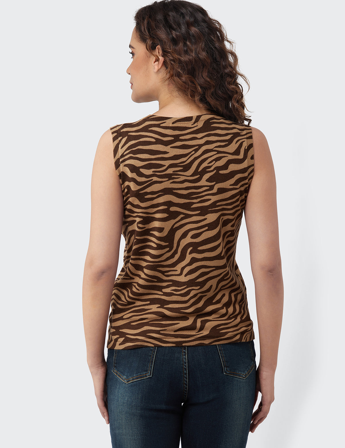 Woman wearing a sleeveless top with zebra pattern on a white background