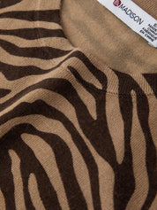 Close-up of brown and beige zebra-striped fabric with a label in the corner.