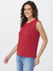Woman wearing a red sleeveless knitted top with a white background