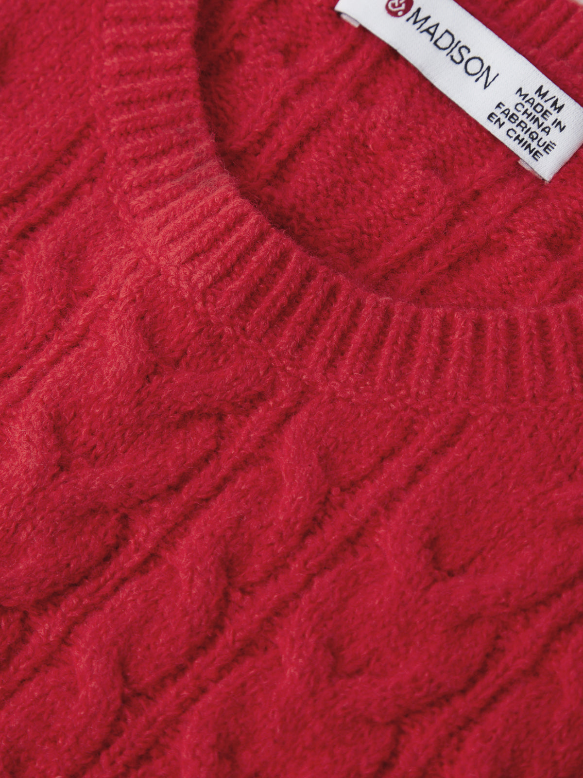 Close-up of a red sweater with a brand label on a white background