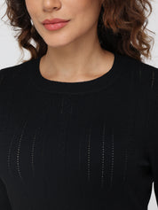 Close-up of a person wearing a black sweater with a blurred background