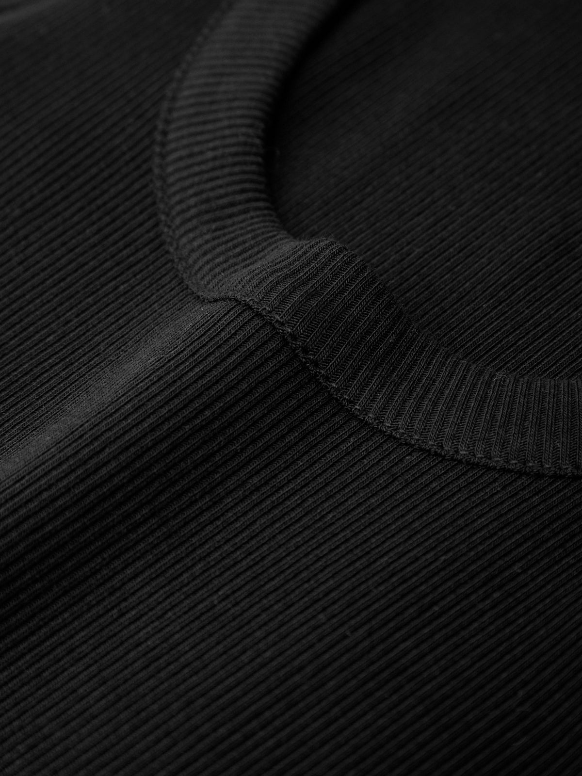 Close-up of a black textured fabric with a ribbed trim.