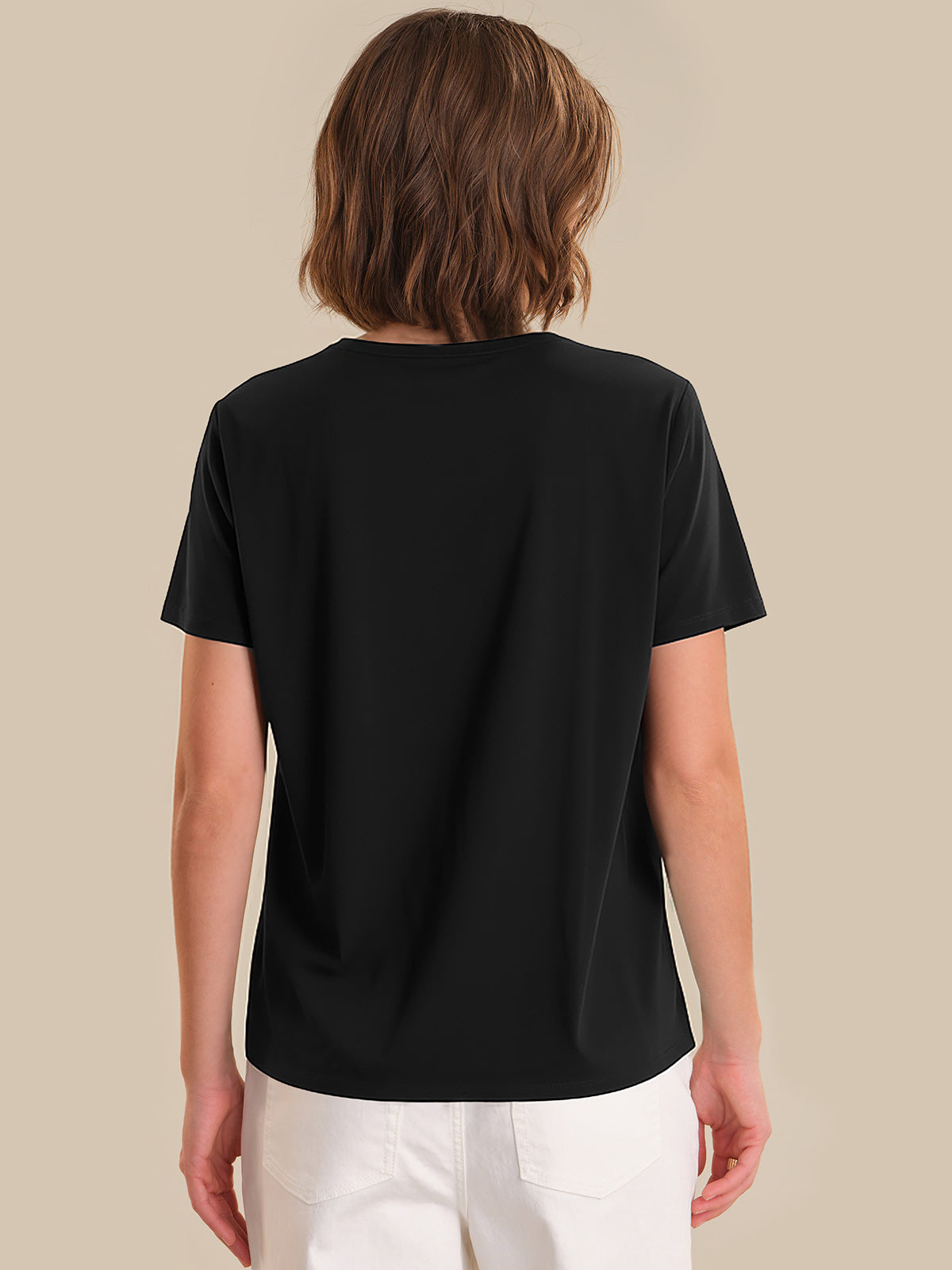 Person wearing a black t-shirt on a beige background
