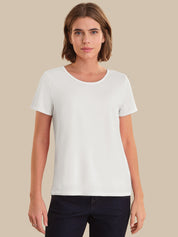 Woman wearing a plain white t-shirt against a beige background