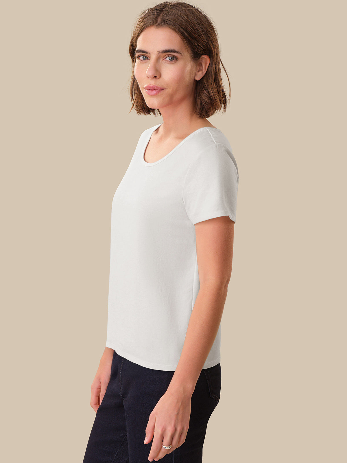 Woman wearing a white t-shirt against a beige background