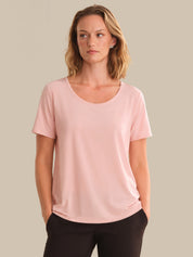 Woman wearing a pink t-shirt against a beige background