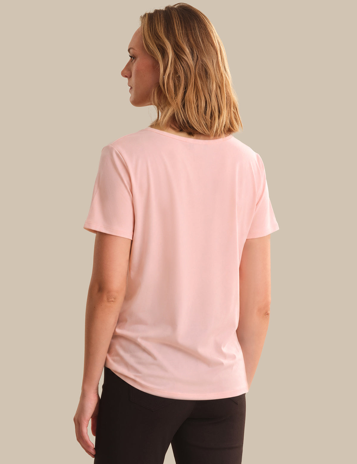 Woman wearing a pink t-shirt on a beige background