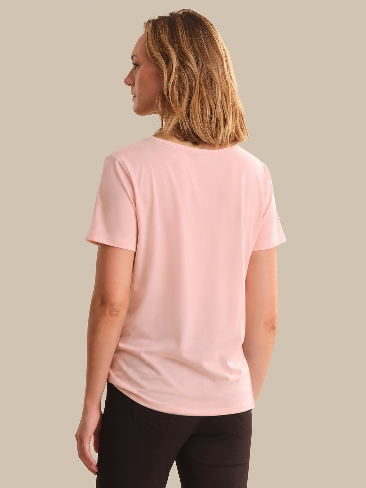 Woman wearing a pink t-shirt on a beige background