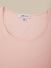 Close-up of a pink garment with a brand label on a beige background
