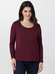 Woman wearing a burgundy long-sleeve top on a white background