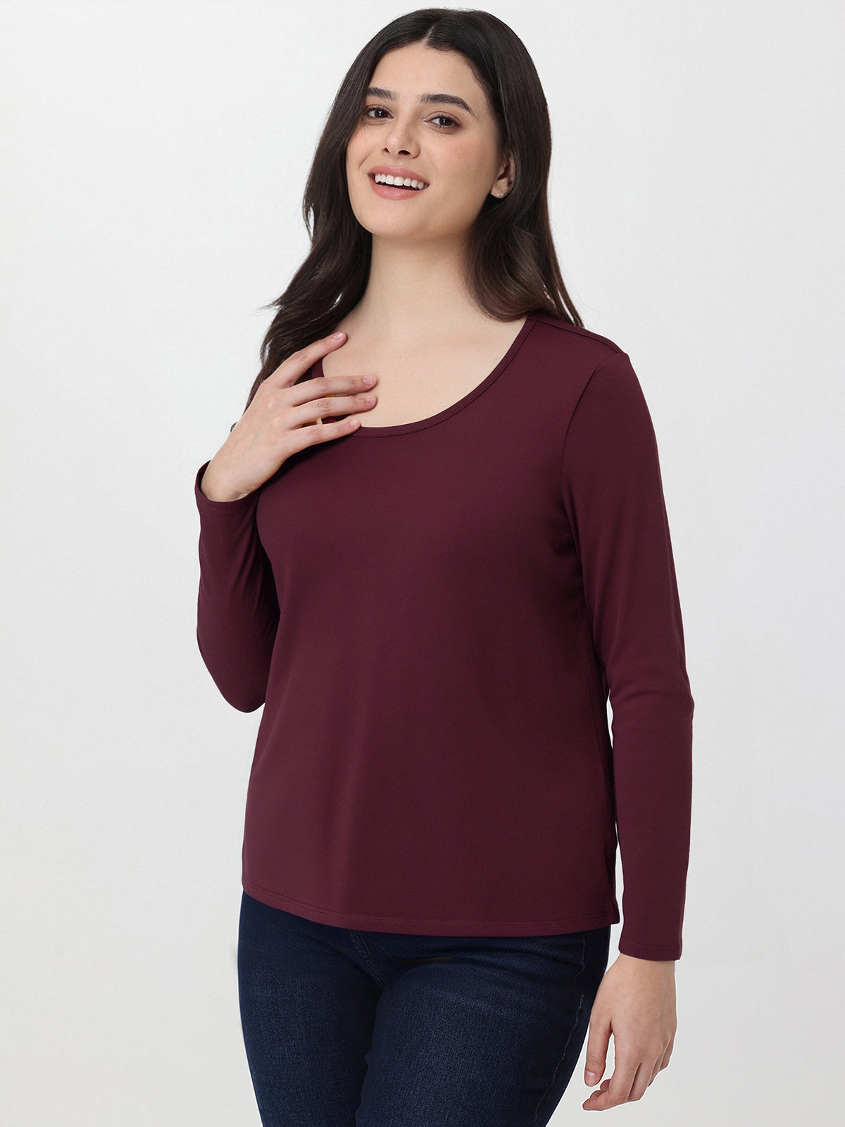 Woman wearing a burgundy long-sleeve top on a white background